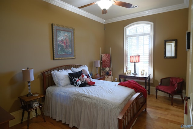 bedroom featuring light hardwood / wood-style floors, ceiling fan, and crown molding