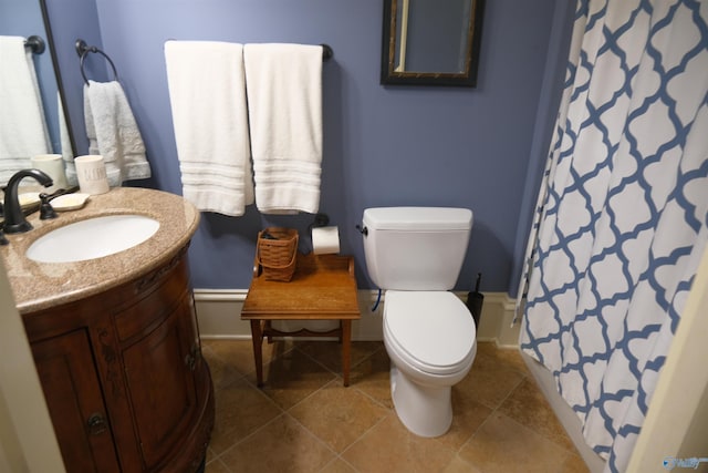 bathroom with toilet, vanity, and tile patterned floors