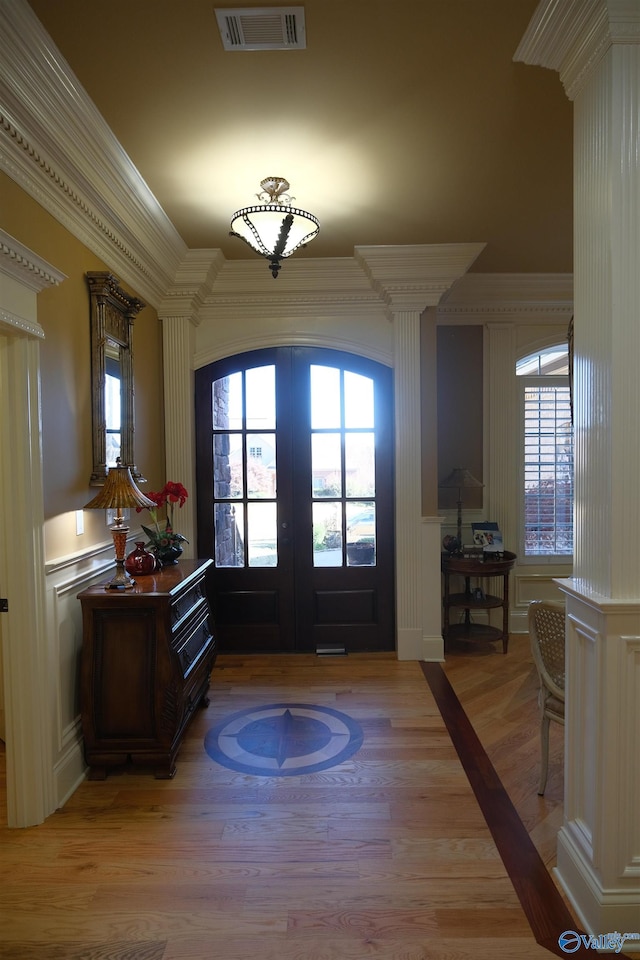 entrance foyer featuring french doors, light hardwood / wood-style floors, and ornamental molding