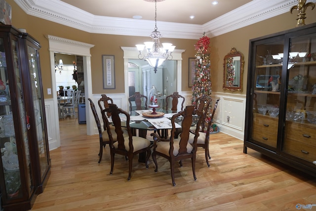 dining area featuring crown molding, a chandelier, and light wood-type flooring