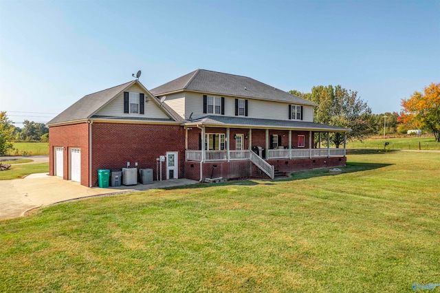 back of property featuring a porch, a garage, a yard, and central air condition unit