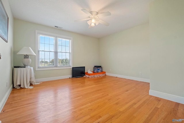 empty room with light hardwood / wood-style flooring and ceiling fan