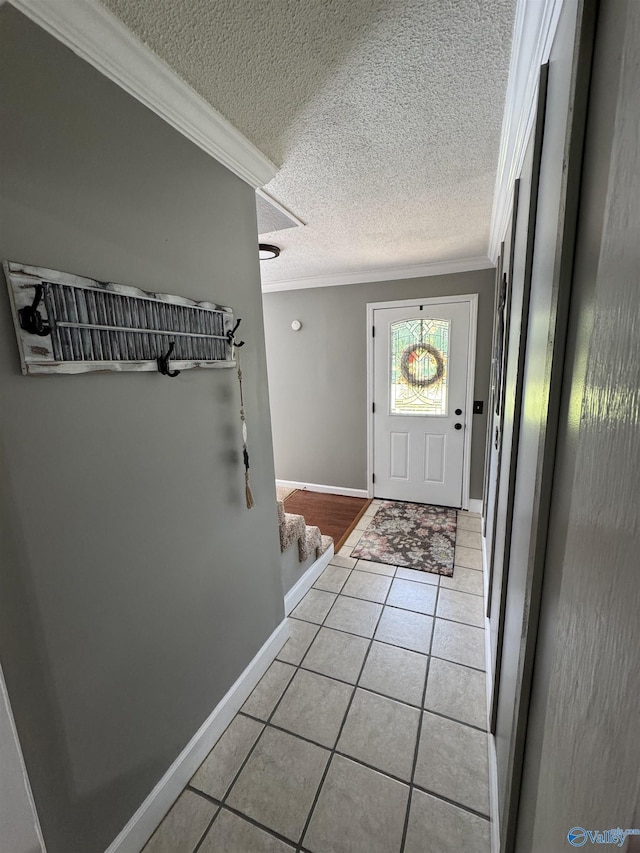 entryway featuring crown molding, light tile patterned flooring, baseboards, and a textured ceiling