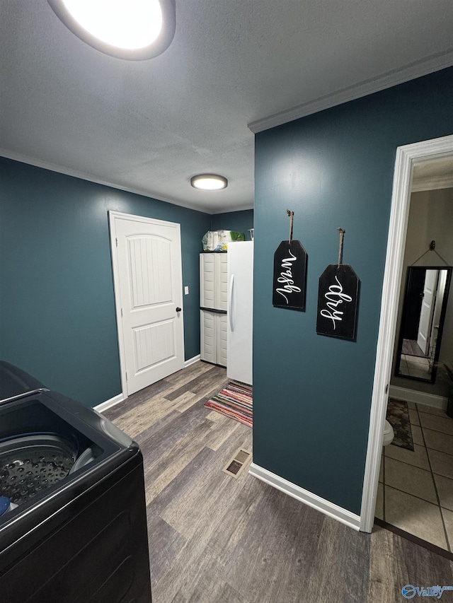 kitchen featuring range, freestanding refrigerator, a textured ceiling, wood finished floors, and baseboards