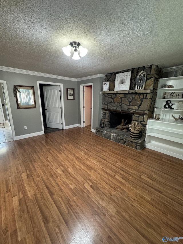 unfurnished living room featuring crown molding, wood finished floors, and a textured ceiling