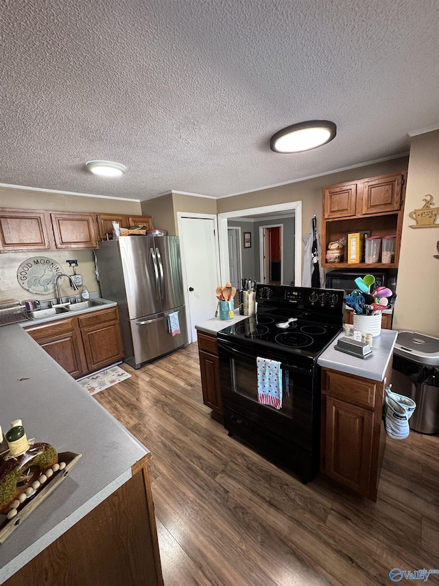 kitchen featuring a sink, light countertops, freestanding refrigerator, dark wood-style floors, and black / electric stove