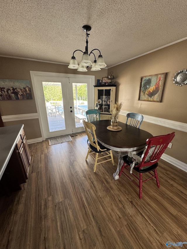 dining space with a textured ceiling, wood finished floors, and an inviting chandelier