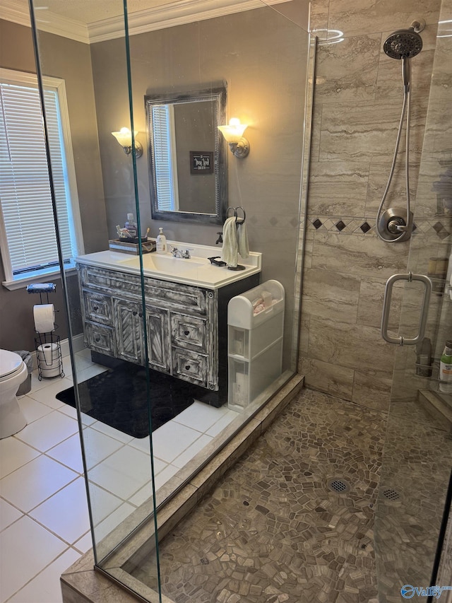 bathroom featuring vanity, ornamental molding, a stall shower, tile patterned flooring, and toilet