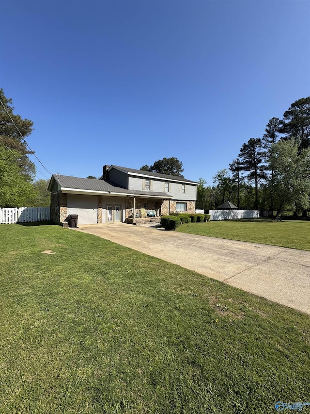 view of front of house featuring concrete driveway, a front yard, fence, and a garage