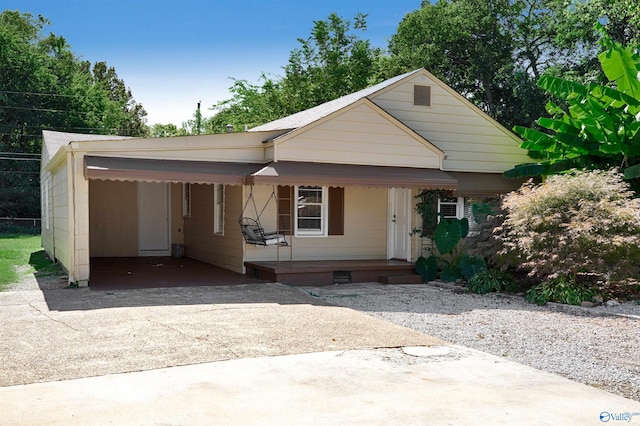 view of front facade with concrete driveway, a carport, covered porch, and crawl space