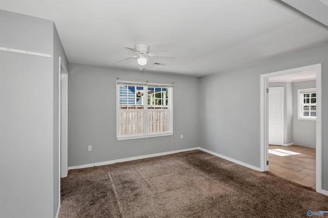 spare room with carpet flooring, baseboards, and ceiling fan