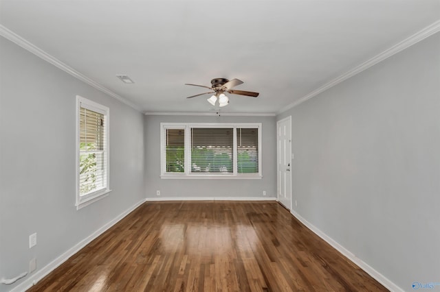 unfurnished room with visible vents, baseboards, wood finished floors, and ornamental molding