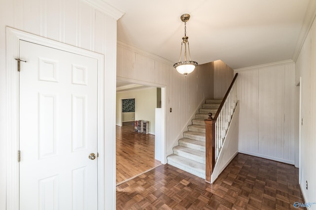 stairway featuring crown molding and parquet flooring