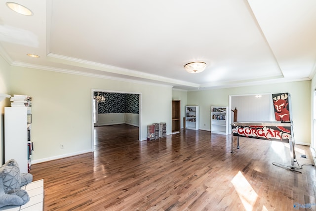 living room with a raised ceiling, crown molding, and dark wood-type flooring