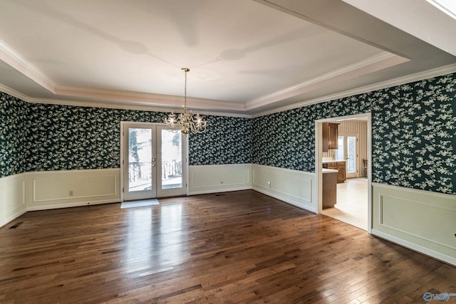 unfurnished dining area with ornamental molding, plenty of natural light, hardwood / wood-style floors, and a notable chandelier