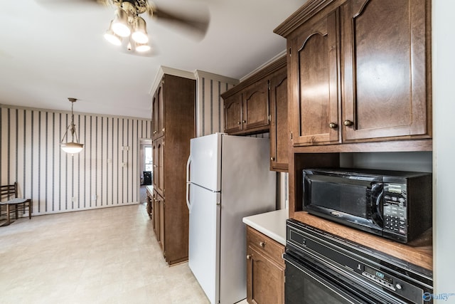 kitchen with ceiling fan, hanging light fixtures, white refrigerator, wall oven, and dark brown cabinetry