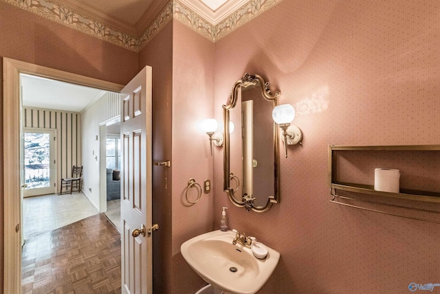 bathroom featuring parquet floors, crown molding, and sink