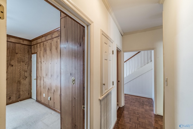 corridor with crown molding, parquet flooring, and wood walls