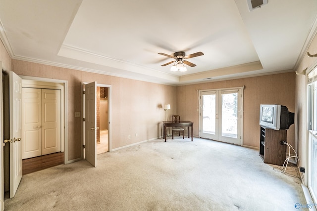 interior space featuring light colored carpet, ornamental molding, and a raised ceiling