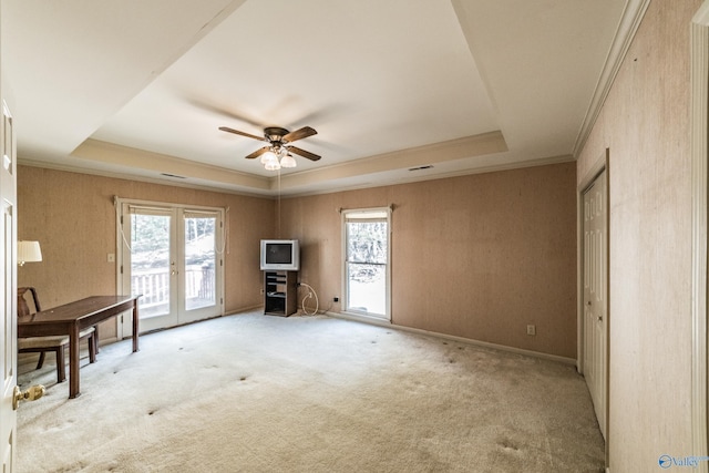 interior space featuring french doors, ceiling fan, ornamental molding, and a raised ceiling