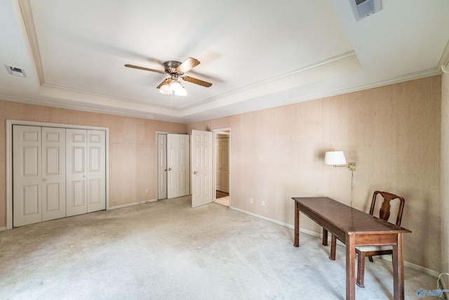 unfurnished office featuring crown molding, a tray ceiling, and ceiling fan