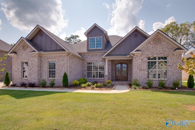 craftsman-style house featuring board and batten siding, french doors, brick siding, and a front lawn