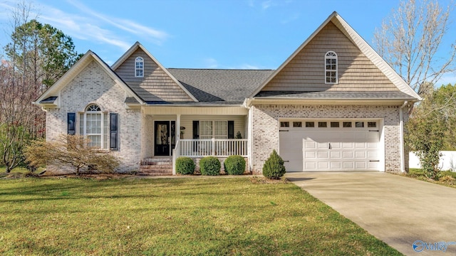 view of front of house featuring a front yard, a porch, an attached garage, concrete driveway, and brick siding