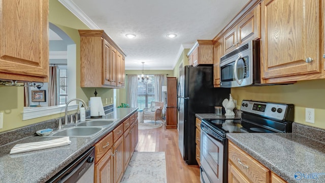 kitchen with crown molding, light wood-type flooring, appliances with stainless steel finishes, an inviting chandelier, and a sink