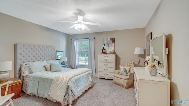 bedroom featuring light carpet, a textured ceiling, and a ceiling fan