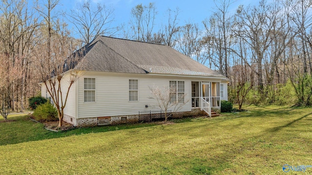 rear view of property with crawl space, a yard, and roof with shingles