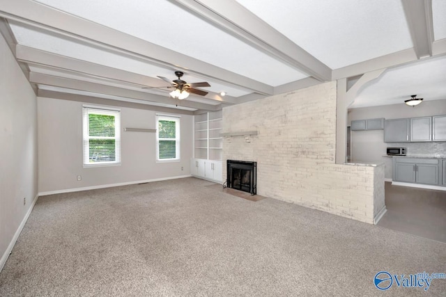 2614 Vista Dr SE, Huntsville, AL 35803 - unfurnished living room with dark colored carpet, baseboards, a ceiling fan, beamed ceiling, and a fireplace with flush hearth