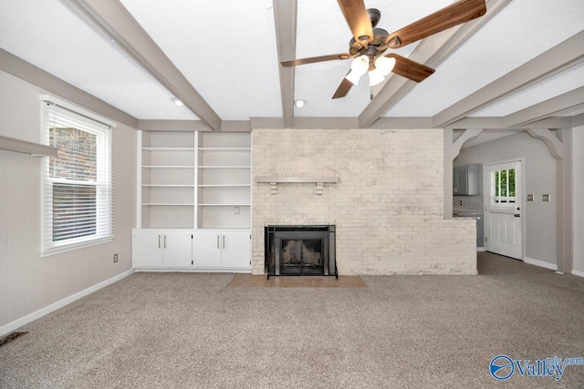 2614 Vista Dr SE, Huntsville, AL 35803 - unfurnished living room featuring a ceiling fan, baseboards, a brick fireplace, carpet flooring, and beam ceiling
