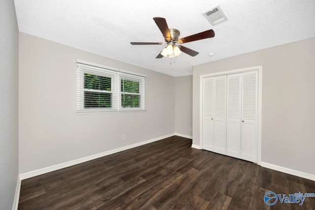 2614 Vista Dr SE, Huntsville, AL 35803 - unfurnished bedroom with dark wood-type flooring, baseboards, a closet, a ceiling fan, and a textured ceiling