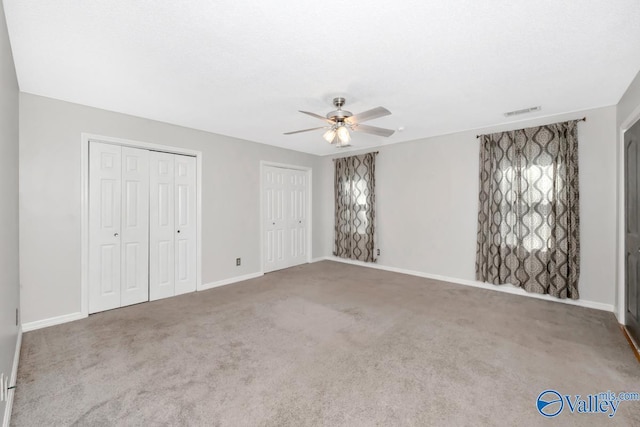 2614 Vista Dr SE, Huntsville, AL 35803 - unfurnished bedroom with multiple closets, carpet, baseboards, and a ceiling fan