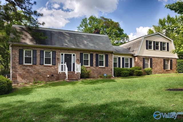 2614 Vista Dr SE, Huntsville, AL 35803 - colonial inspired home featuring brick siding, a gambrel roof, a front lawn, and a chimney