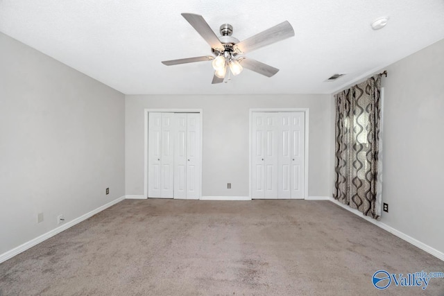 2614 Vista Dr SE, Huntsville, AL 35803 - unfurnished bedroom with multiple closets, carpet flooring, baseboards, and a ceiling fan