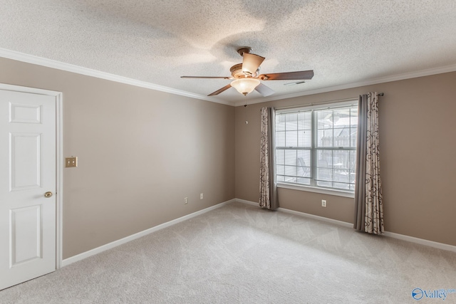 carpeted empty room with ceiling fan, ornamental molding, and baseboards