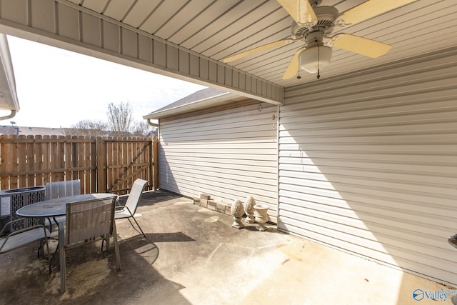 view of patio with cooling unit, outdoor dining area, fence, and ceiling fan