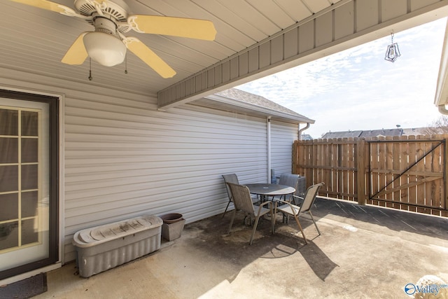 view of patio featuring a ceiling fan, outdoor dining space, and fence