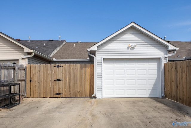 garage featuring driveway and fence