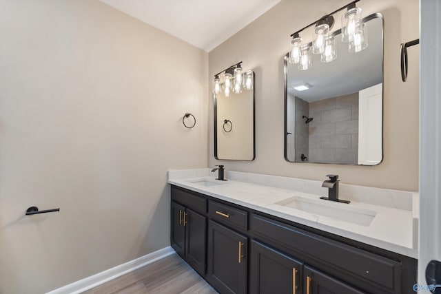 12034 Runningmeade Trl SE, Huntsville, AL 35803 - bathroom with double vanity, baseboards, wood finished floors, and tiled shower