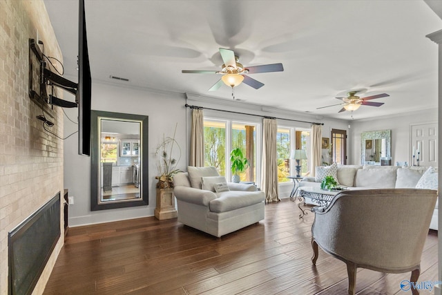 living room with brick wall, ceiling fan, wood-type flooring, and a brick fireplace