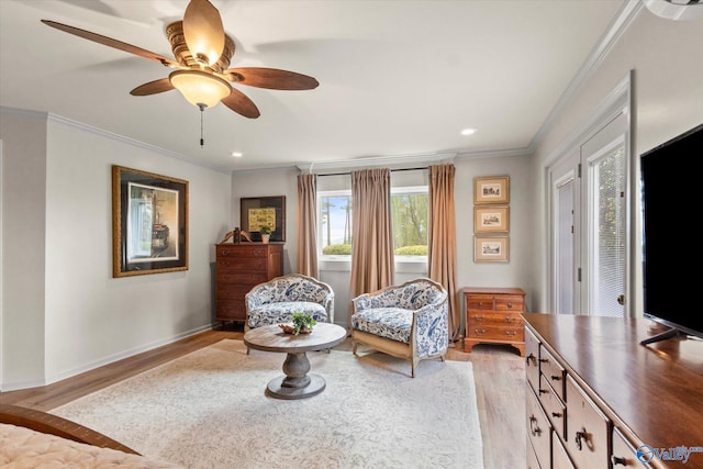 living area with light wood-type flooring, ceiling fan, and ornamental molding