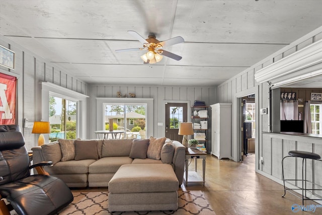 living room with concrete flooring and ceiling fan