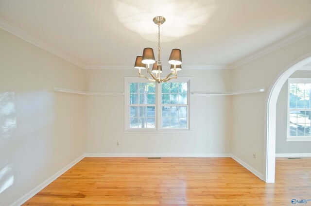 unfurnished dining area featuring ornamental molding, a chandelier, and hardwood / wood-style floors