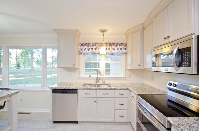 kitchen featuring hanging light fixtures, light stone countertops, sink, crown molding, and stainless steel appliances