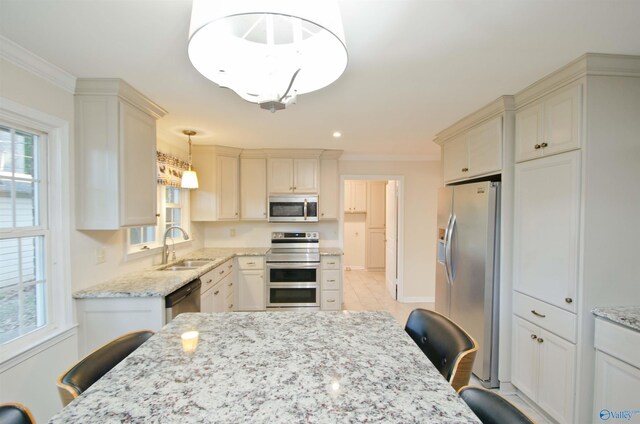 kitchen featuring sink, a breakfast bar, appliances with stainless steel finishes, and hanging light fixtures