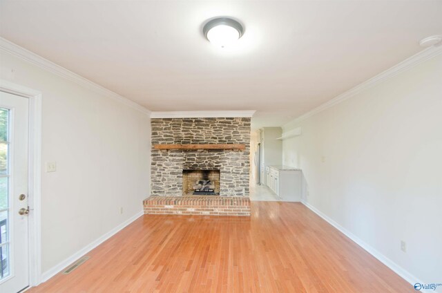 unfurnished living room with ornamental molding, a fireplace, and light hardwood / wood-style floors