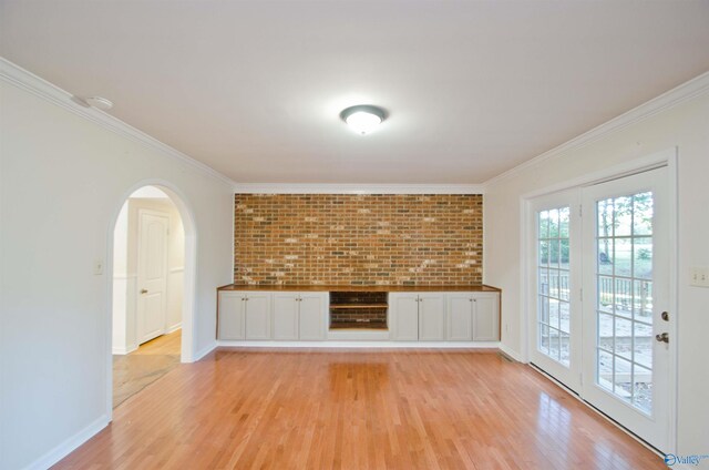 unfurnished living room featuring ornamental molding and light hardwood / wood-style floors