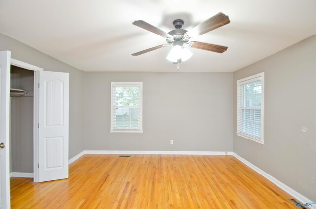 unfurnished bedroom with wood-type flooring, a closet, and ceiling fan